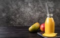 Fresh mango shake in a glass with a metal drinking straw decorated with slices of mango front view on dark wooden background Royalty Free Stock Photo