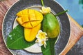 Fresh mango on a wooden tabel with tropical background. Soft focus. Royalty Free Stock Photo