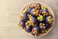 Fresh mangosteen in bamboo basket on wooden table. Healthy and sweet fruit. High vitamins