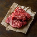 Fresh marbled beef cuts on brown paper displayed on rustic surface Royalty Free Stock Photo