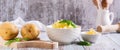 Fresh mashed potatoes and basil leaves in a bowl and whole potatoes on the table web banner