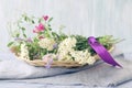 Fresh meadow flowers in a wicker basket on a wooden table, a bouquet of flowers Royalty Free Stock Photo