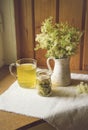 Fresh Meadowsweet, Filipendula ulmaria in jug shape vase and it`s herbal tea in glass, tea powder in jar.