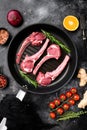 Fresh meat cutlet, on frying cast iron pan, on black dark stone table background, top view flat lay Royalty Free Stock Photo