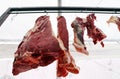 Fresh meat pieces hanged from metallic hooks