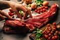 Fresh meat preparation and portioning.Whole uncut beef tenderloin.Raw meat seasoning.Man hands cutting up filet mignon steaks. Royalty Free Stock Photo