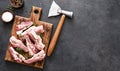 Fresh meat. Raw pork ribs with spices and an ax on a wooden board on a black background. View from above Royalty Free Stock Photo