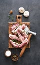 Fresh meat. Raw pork ribs with spices and an ax on a wooden board on a black background. View from above Royalty Free Stock Photo