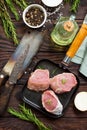 Fresh meat. Raw pork steak on a cast iron frying pan, spices and fresh rosemary on a kitchen wooden table. Royalty Free Stock Photo