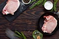 Fresh meat. Raw steak cutlet on a bone on a cast-iron frying pan, olive oil, spices and fresh rosemary on the kitchen table. Royalty Free Stock Photo