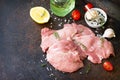 Fresh meat. Raw turkey fillet, tomatoes, olive oil, spices and lemons on a stone table.