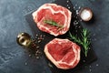 Fresh meat on slate black board top view. Raw beef steak and spices for cooking Royalty Free Stock Photo