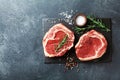 Fresh meat on slate black board top view. Raw beef steak and spices for cooking Royalty Free Stock Photo