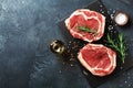Fresh meat on slate black board top view. Raw beef steak and spices for cooking Royalty Free Stock Photo