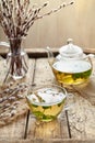 Fresh melissa tea in glass cup, teapot and willow twigs Royalty Free Stock Photo