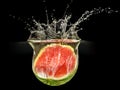 Fresh melon falling in water with splash on black background Royalty Free Stock Photo