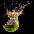 Fresh melon falling in water with splash on black Royalty Free Stock Photo