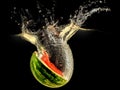 Fresh melon falling in water with splash on black background Royalty Free Stock Photo