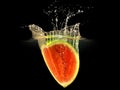 Fresh melon falling in water with splash on black background Royalty Free Stock Photo