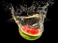 Fresh melon falling in water with splash on black background Royalty Free Stock Photo