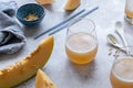 Fresh melon juice on the table with cloudy sky background, preparing melon juice by raw ripe biological fruit Royalty Free Stock Photo