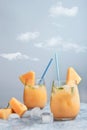 Fresh melon juice on the table with cloudy sky background, preparing melon juice by raw ripe biological fruit Royalty Free Stock Photo