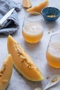 Fresh melon juice on the table with cloudy sky background, preparing melon juice by raw ripe biological fruit Royalty Free Stock Photo