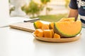 Fresh melons sliced on wooden plate on white table background. Royalty Free Stock Photo