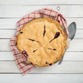 Fresh and Messy Baked Blackberry Pie with Red Plaid Towel and Server on White Shiplap Board Background Table with Square Crop and