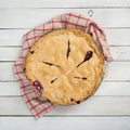 Fresh and Messy Baked Blackberry Pie with Red Plaid Towel on White Shiplap Board Background Table with Square Crop and above, look Royalty Free Stock Photo