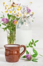 Fresh milk in ceramic mug and wildflowers Royalty Free Stock Photo