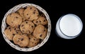 Fresh Milk and Chocolate chip cookies in a bamboo basket isolated on black background Royalty Free Stock Photo