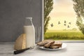 Fresh milk,cream bottle,bread,cheese in window to countryside Royalty Free Stock Photo
