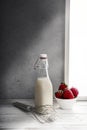 Fresh milk,cream bottle on window sill with strawberries Royalty Free Stock Photo