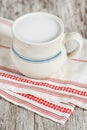 Fresh milk in cream ceramic mug on the old table Royalty Free Stock Photo