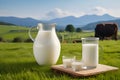 Fresh milk in a glass and in a jug on a wooden tabletop and a blurred landscape with a cow in a meadow. Healthy eating Royalty Free Stock Photo