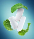 Fresh mint leaves and chewing gum pads flying on light blue background Royalty Free Stock Photo