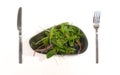 Fresh mix green salad leaves on silver plate with knife and fork isolated on white background