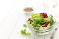 Fresh mix salad in bowl with glass of water on wooden table. Royalty Free Stock Photo