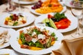 Fresh mix salad with ham, feta and mango on white plate. restaurant table setting Royalty Free Stock Photo