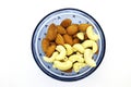 Fresh Mixed Almonds and Cashew nuts in a blue bowl, Top view. White isolated background Royalty Free Stock Photo