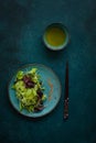 Fresh mixed baby salad leaves with olive oil and chopsticks on green background