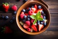 fresh mixed berries and fruit salad in bowl on top of wooden table Royalty Free Stock Photo