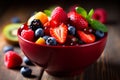 fresh mixed berries and fruit salad in bowl on top of wooden table Royalty Free Stock Photo