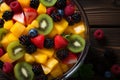 Fresh mixed fruit salad in glass bowl on rustic wooden table, top view overhead shot Royalty Free Stock Photo