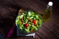 Fresh mixed green salad in bowl on wooden table close up. Concept healthy lifestyle and simple food