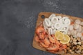 Fresh mixed seafood on wood desk isolated on gray background. Shrimp, squid rings, scallop Royalty Free Stock Photo