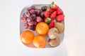 Fresh mixed sweet fruit on plate over white Royalty Free Stock Photo