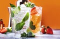 Fresh Mojito cocktail set with lime, mint, strawberry and ice in glass on orange background. Summer cold alcoholic non-alcoholic Royalty Free Stock Photo