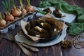 Fresh morel mushrooms on a plate and green onions on a wooden background, close-up. The first spring mushrooms Royalty Free Stock Photo